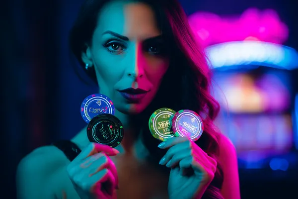 A woman smiling by bright slot machines showing lucky symbols, showcasing the exciting slot offerings at SUPERJILI.